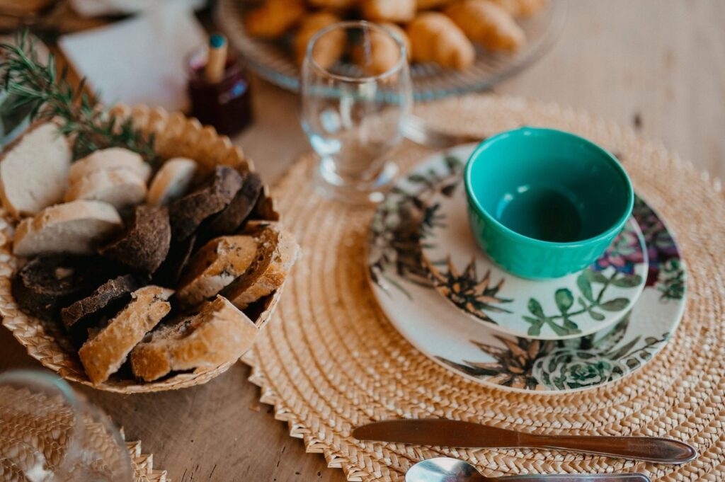Rustieke ontbijttafel met brood, gebak, glas en turquoise kopje
