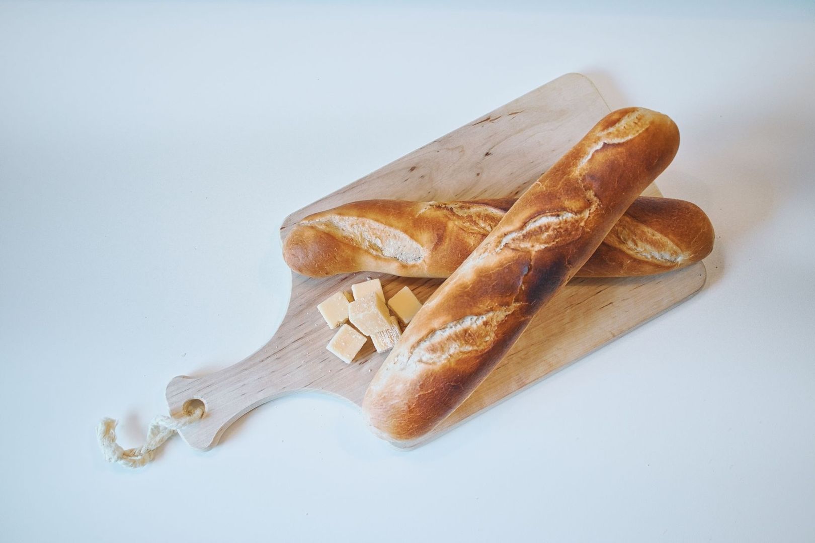 Ambachtelijke broodjes en stukjes kaas op een houten plank